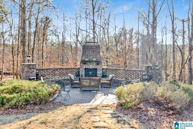 view of yard with an outdoor living space with a fireplace and a patio