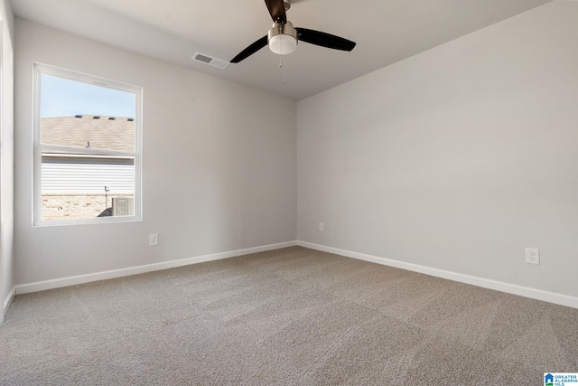 carpeted spare room featuring baseboards, a ceiling fan, and visible vents
