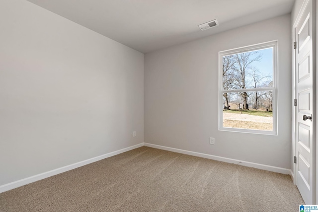 carpeted spare room featuring baseboards and visible vents
