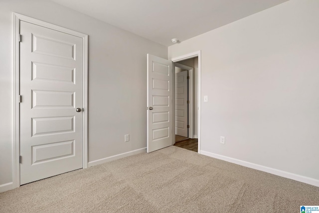 unfurnished bedroom featuring carpet flooring and baseboards