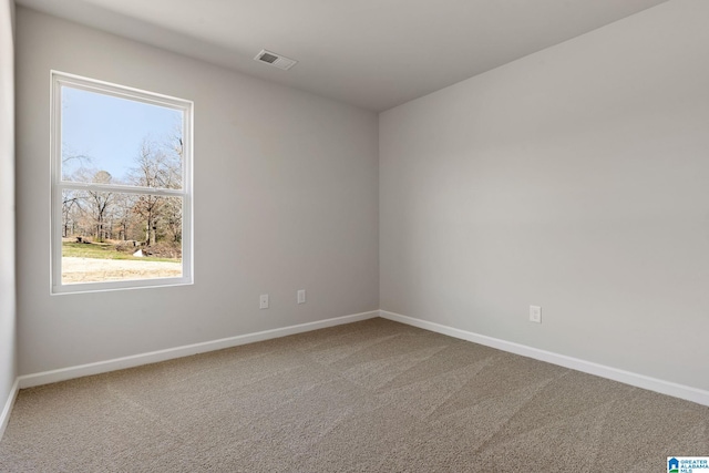 spare room featuring visible vents, baseboards, and carpet floors
