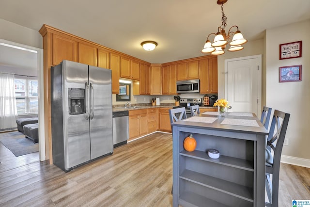 kitchen with sink, light hardwood / wood-style flooring, a notable chandelier, and appliances with stainless steel finishes