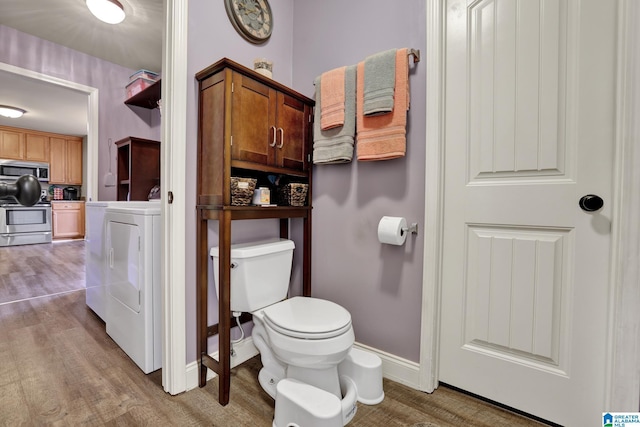 bathroom with hardwood / wood-style flooring, toilet, and washer / clothes dryer