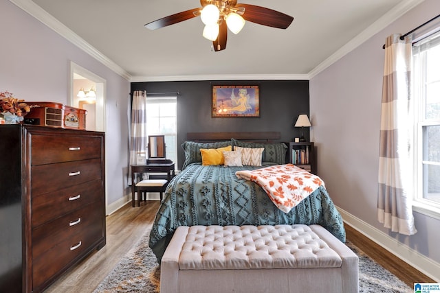 bedroom featuring hardwood / wood-style flooring, ceiling fan, and multiple windows