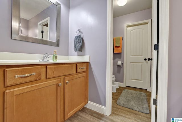 bathroom featuring hardwood / wood-style floors, vanity, and toilet