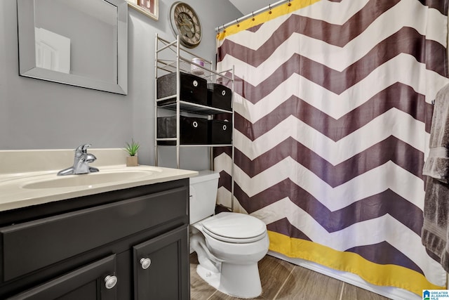 bathroom with curtained shower, vanity, and toilet