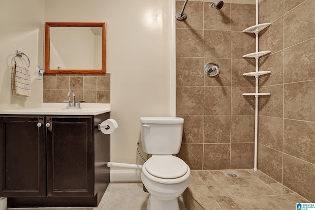 bathroom with tiled shower, vanity, tasteful backsplash, and toilet