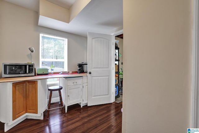 kitchen featuring dark hardwood / wood-style floors and white cabinetry