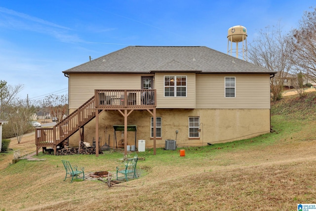 back of house with a fire pit, a wooden deck, a lawn, and central AC