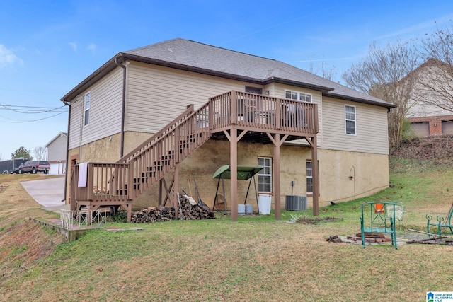 rear view of property featuring central air condition unit, a yard, and a deck