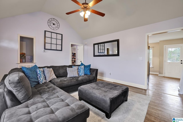 living room featuring ceiling fan, hardwood / wood-style floors, and vaulted ceiling