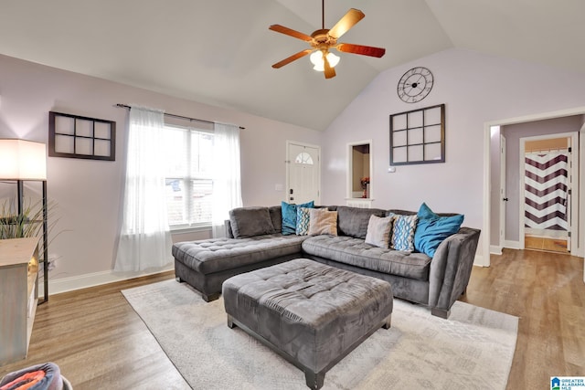 living room featuring ceiling fan, light hardwood / wood-style flooring, and vaulted ceiling