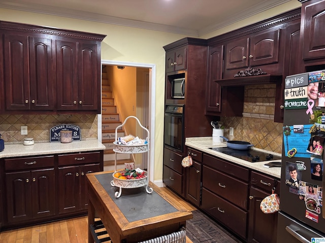 kitchen featuring decorative backsplash, black appliances, crown molding, and light wood-type flooring