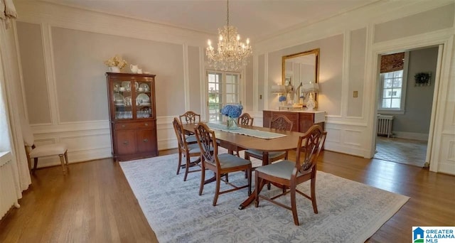 dining room featuring dark hardwood / wood-style floors, radiator, and a notable chandelier