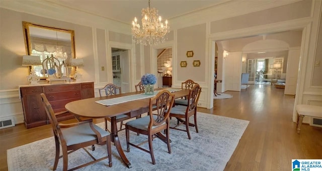 dining room with a chandelier, french doors, and light hardwood / wood-style floors