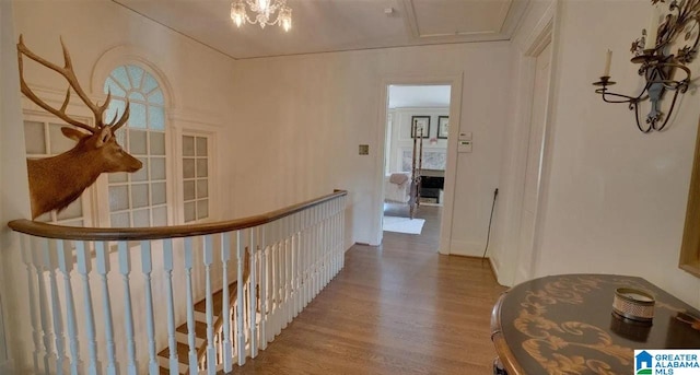 corridor with hardwood / wood-style floors and a chandelier