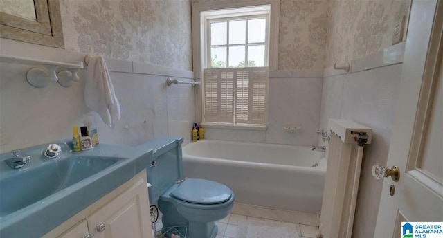 bathroom with tile patterned floors, a bathing tub, vanity, and toilet