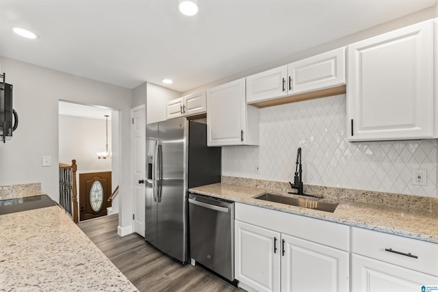 kitchen with backsplash, dark wood-type flooring, white cabinets, sink, and appliances with stainless steel finishes