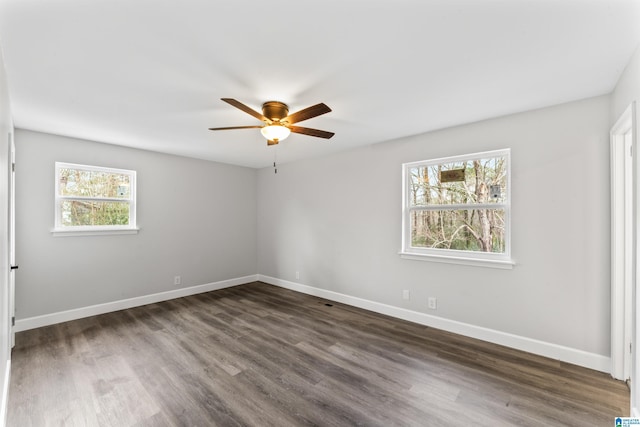 empty room with plenty of natural light, dark hardwood / wood-style floors, and ceiling fan