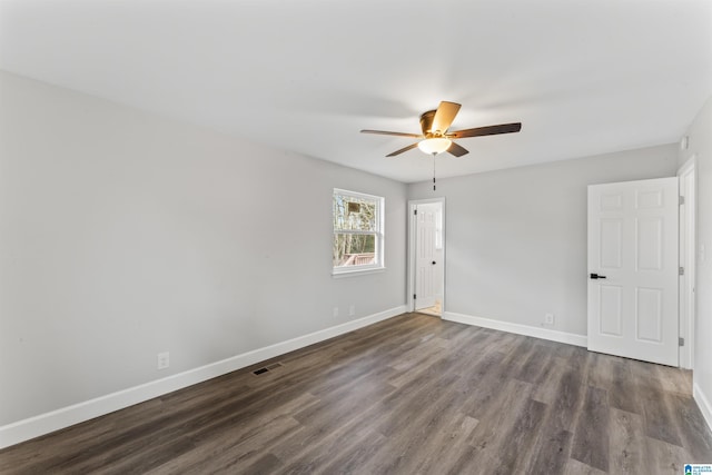 spare room with dark hardwood / wood-style floors and ceiling fan