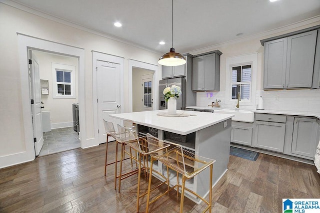 kitchen featuring gray cabinetry, sink, hanging light fixtures, a kitchen island, and stainless steel fridge with ice dispenser