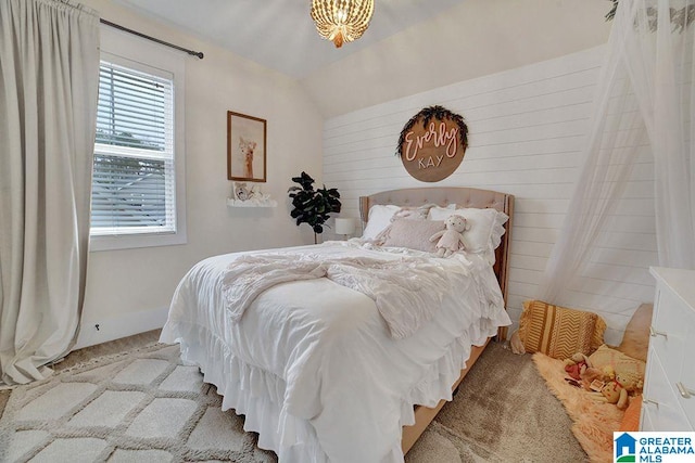 carpeted bedroom with lofted ceiling and an inviting chandelier