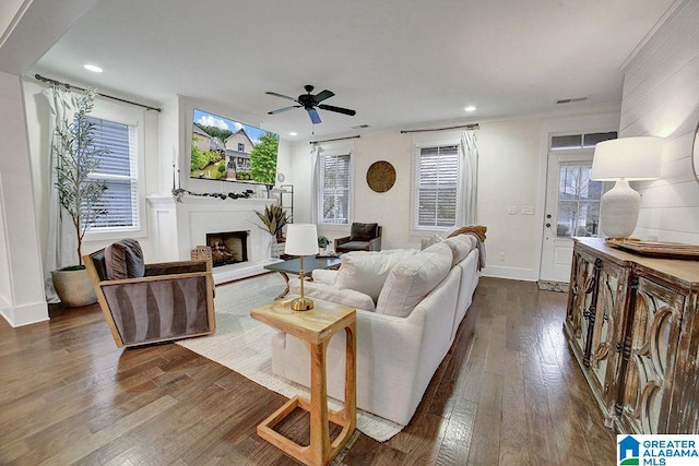 living room with ornamental molding, dark hardwood / wood-style flooring, ceiling fan, and a healthy amount of sunlight