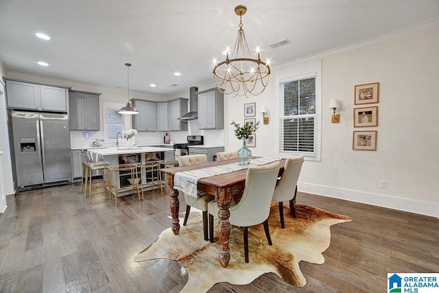 dining room with crown molding, a chandelier, and hardwood / wood-style flooring