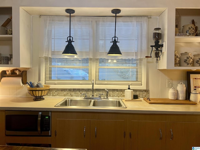 kitchen featuring a wealth of natural light, hanging light fixtures, and sink