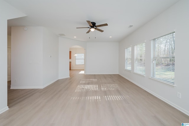 empty room featuring ceiling fan, light hardwood / wood-style floors, and plenty of natural light