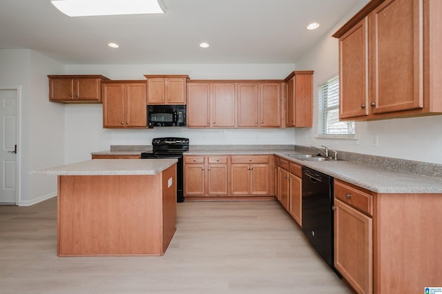 kitchen featuring sink, a center island, black appliances, and light hardwood / wood-style flooring