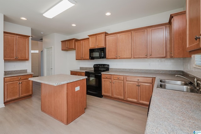 kitchen featuring sink, a center island, light hardwood / wood-style flooring, and black appliances