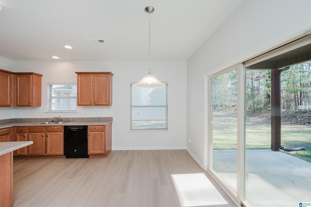 kitchen featuring decorative light fixtures, black dishwasher, a wealth of natural light, and light hardwood / wood-style flooring