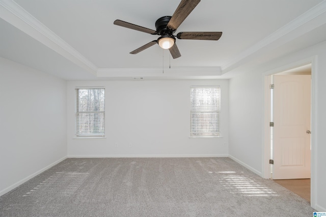 spare room with a wealth of natural light, a tray ceiling, ceiling fan, and light colored carpet