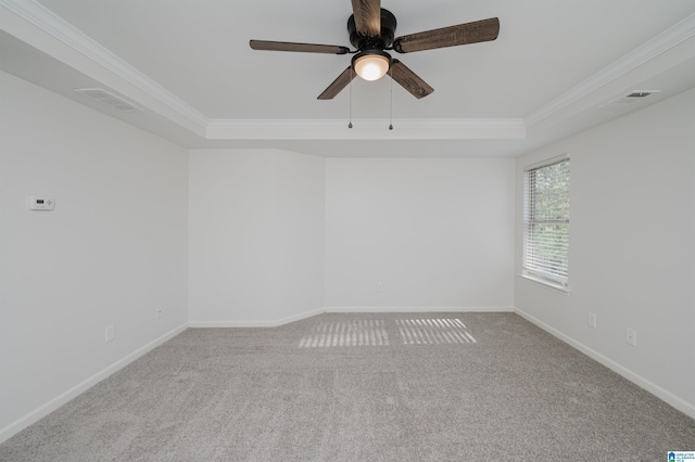 empty room with carpet floors, a raised ceiling, ceiling fan, and crown molding