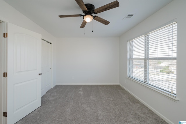 carpeted spare room with ceiling fan