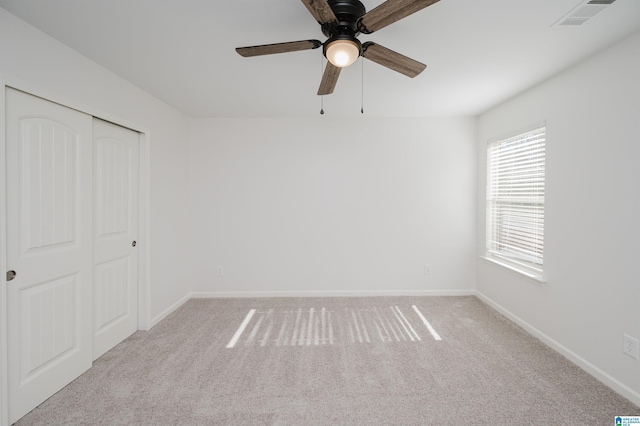 unfurnished bedroom with light carpet, a closet, and ceiling fan