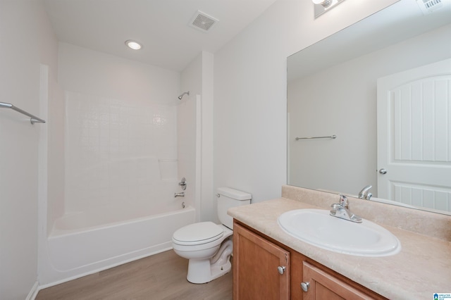 full bathroom featuring hardwood / wood-style flooring, vanity, bathtub / shower combination, and toilet