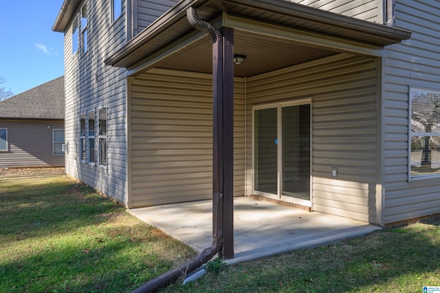 view of side of home featuring a yard and a patio