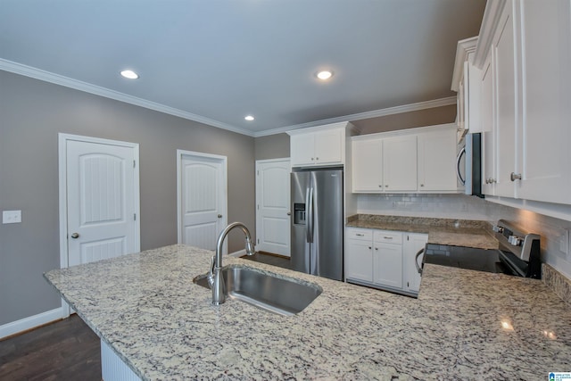 kitchen with appliances with stainless steel finishes, tasteful backsplash, light stone counters, sink, and white cabinetry