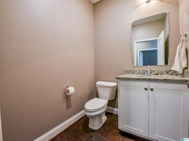 bathroom with vanity, hardwood / wood-style flooring, and toilet