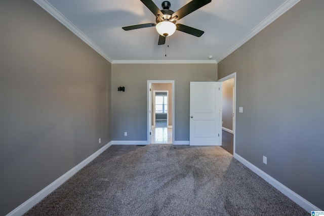 carpeted spare room with ceiling fan and ornamental molding