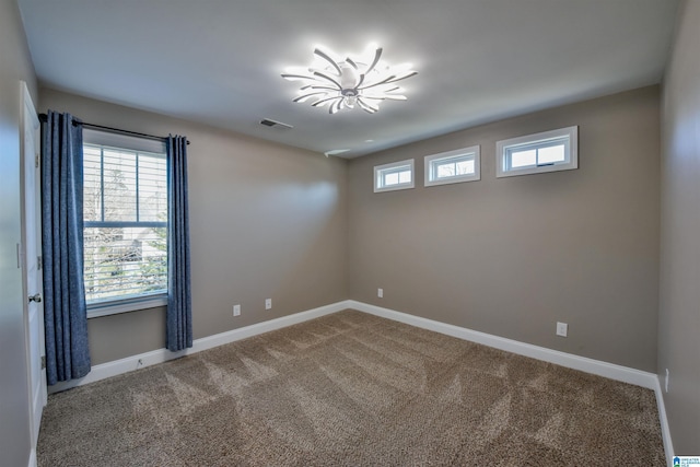 unfurnished room featuring carpet floors and a notable chandelier