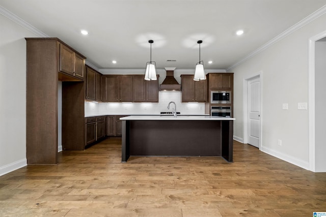 kitchen with stainless steel appliances, custom exhaust hood, hanging light fixtures, and light hardwood / wood-style floors