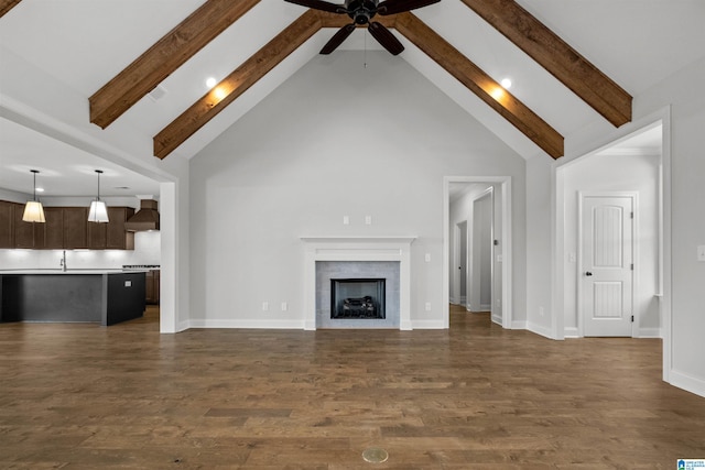 unfurnished living room with beamed ceiling, dark wood-type flooring, and high vaulted ceiling