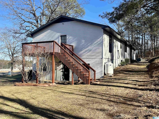 back of property featuring cooling unit, a yard, and a wooden deck