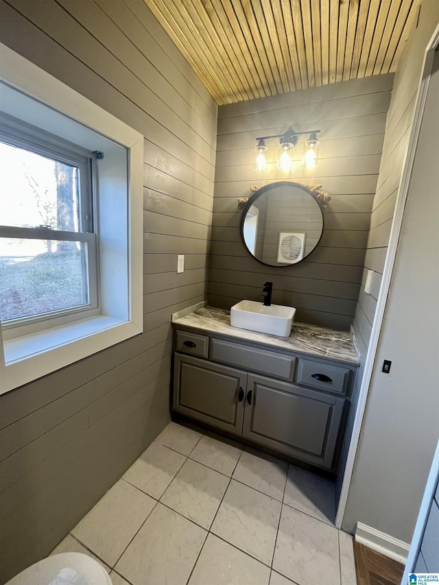 bathroom with tile patterned flooring, vanity, wooden walls, and wooden ceiling