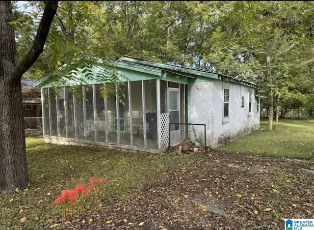 view of outbuilding featuring a sunroom and a yard