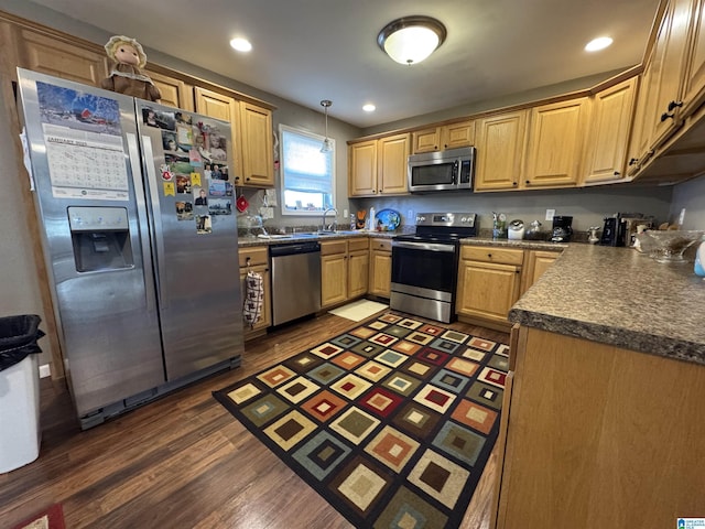 kitchen with sink, hanging light fixtures, dark hardwood / wood-style floors, and stainless steel appliances