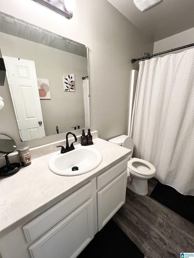 bathroom with a shower with curtain, vanity, hardwood / wood-style flooring, and toilet